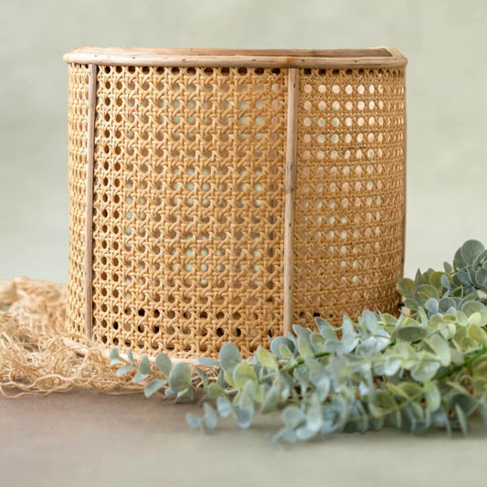 Woven basket with a light background and greenery